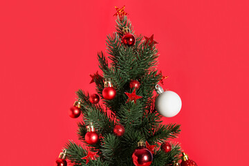 Small Christmas tree with decor on red background