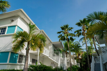 Fototapeta premium White residential buildings with staircase to the entrance near the trees outdoors- Miami, Florida