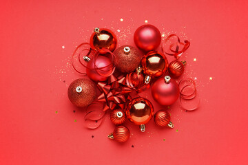 Christmas balls with serpentine and bow on red background