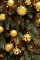 Obraz na płótnie Canvas Glowing Christmas tree with balls in room, closeup