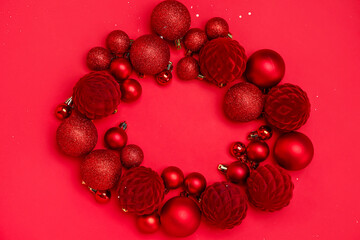 Frame made of red Christmas balls on color background
