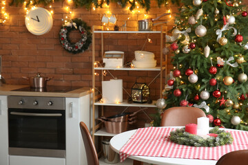 Dining table with Christmas wreath and candles in kitchen