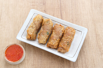 Lumpia Kulit Tahu, chicken shrimp spring rolls wrapped in tofu skin. Served with sauce.
