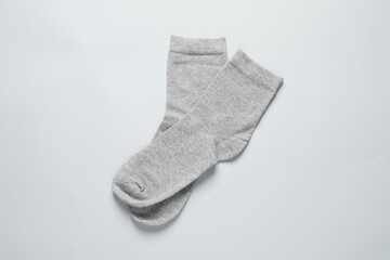 Pair of grey socks on light background, flat lay