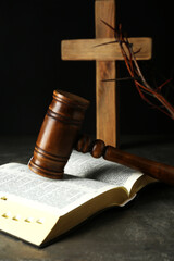 Judge gavel, bible, wooden cross and crown of thorns on grey table
