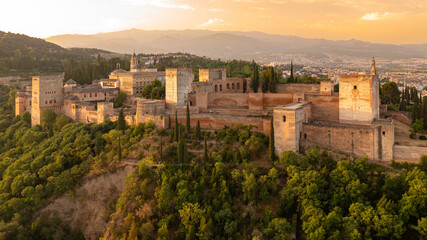 Fototapeta na wymiar Sunrise aerial photo of the Alhambra fortress in Granada, Spain. The fortress is bathed in golden light.