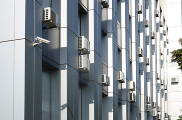 Many HVAC air conditioning and ventilation systems on wall. Outdoor Air conditioning units mounted...