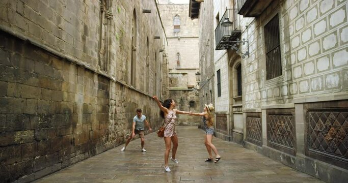 Winter rain, dance and fun friends happy, excited and dancing on travel adventure of Barcelona Spain for Europe tour. Concrete buildings, dancer energy or man and women playing on outdoor vacation