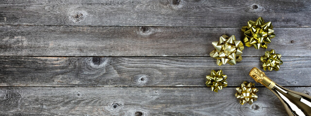 Fototapeta premium New Year celebration background with golden champagne bottle and bows. Perfect for other events like Christmas, birthday or anniversary