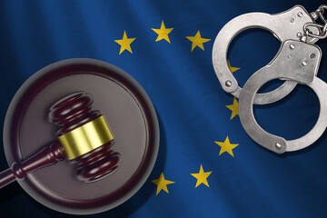 European union flag with judge mallet and handcuffs in dark room. Concept of criminal and...