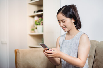 Cheerful mature woman using smartphone working at home office 