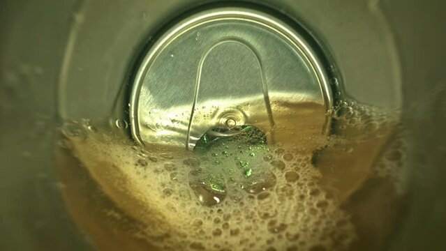 View from inside empty sugar drink soda pop drink can in extreme closeup. Pov inside from aluminum metal jar camera in soda pop can when sugar drink water is pours out super macro slow motion 1000fps