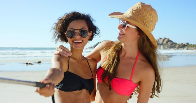 Smartphone, beach and friends on a selfie stick for social media post of summer vacation, holiday and travel destination. Diversity influencer women in bikini, sunglasses and phone photography at sea
