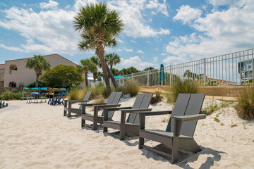 Fototapeta na wymiar Lounge chairs near the grasses beside the fence railings in Destin, Florida