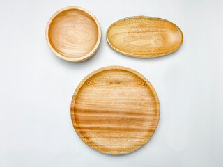 Flat lay of the empty wooden plate and wooden bowl on white background.