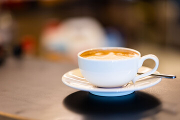 A cup of hot latte on the table in the cafe.