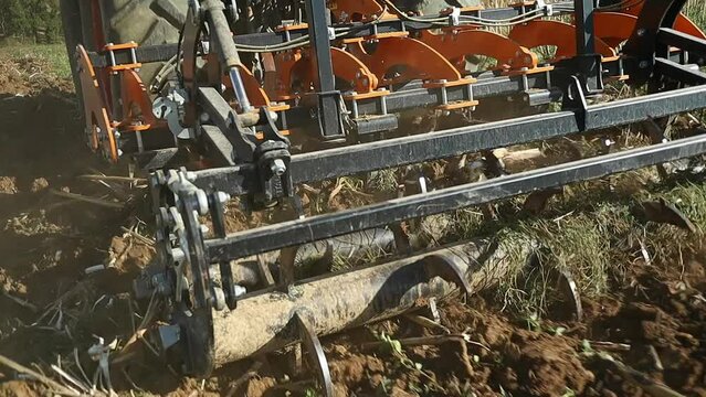 close up of agricultural land preparation with a subsoiler attached to the heavy tractor, slow motion shot