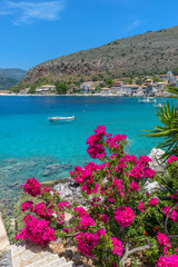 view of  Limeni village with the famous  stone buildings, a blooming bougainvillea, and turquoise waters a as a background  in Mani, South Peloponnese , Greece.