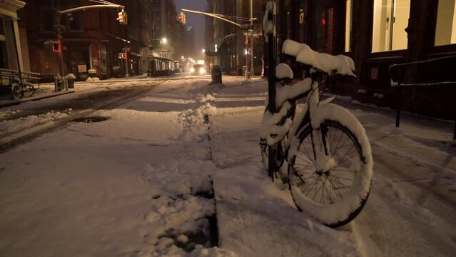 Snow covered bicycle stand on the sidewalk of Soho street before sunrise in Manhattan, New York
