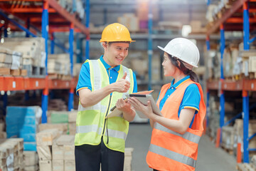 Asian engineer in helmets order and checking goods and supplies on shelves with goods background in warehouse.logistic and business export ,Warehouse worker checking packages on shelf in a large store