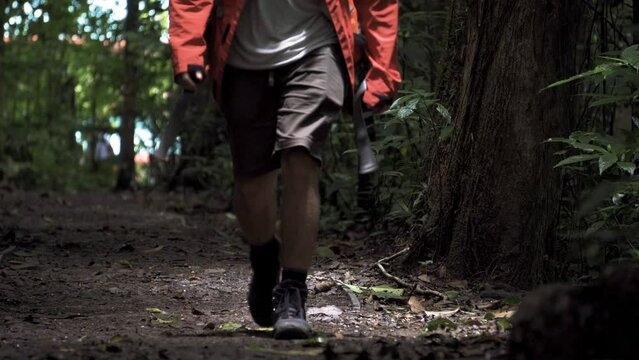 traveller backpacking jungle rainforest path in Costa Rica close up of walking trekking shoes on wild lonely road