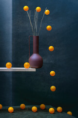 Still life with a vase on the shelf and orange balls