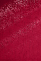 Textured wall with shadow. Demonstrating the colors of 2023 - Viva Magenta.
