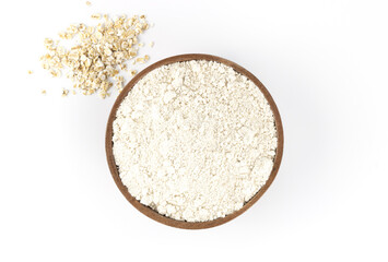 Oatmeal in a wooden bowl with oatmeal on a white background, macro. Baking ingredients. Gluten free concept.