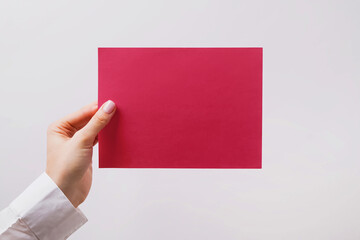Woman holding paper of vivid magenta color.