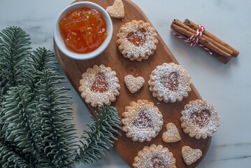 sweet home made linzer christmas cookies filled with apricot jam on a table