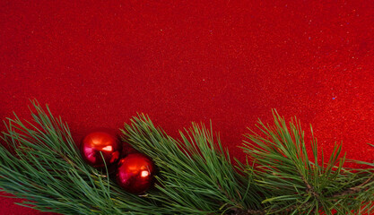 Red Christmas background with Christmas tree branch and Christmas balls and toys