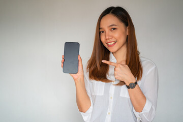 Portrait of a beautiful woman pointing finger at smartphone in hand.