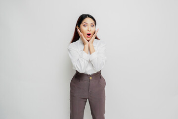 Shocked Asian woman wearing white shirt and looking at the camera, isolated by white background
