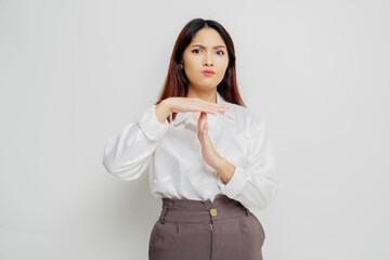 Hispanic Asian woman wearing white shirt doing time out gesture with hands, frustrated and serious face