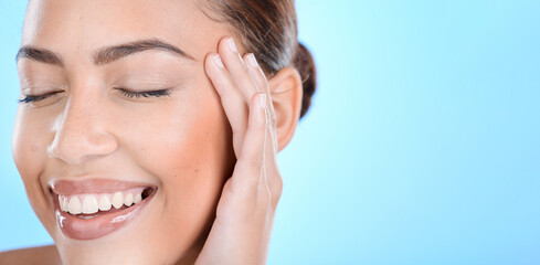 Obraz premium Face, beauty and mockup with a model black woman in studio on a blue background for natural skincare. Happy, smile and cosmetics with an attractive young female posing to promote advertising space