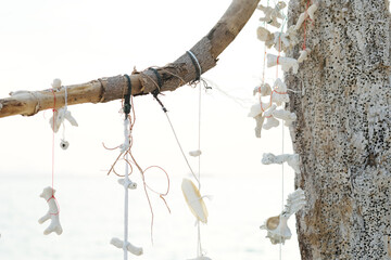 White corals and seashells tied with white string decorate the beach. Thailand tourism concept.