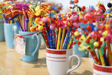 Fototapeta na wymiar Colorful children's pencils with cute plastic cartoon decorations on top