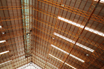 Steel roof structure of the gymnasium. Detail of steel roof structure with transparent tile strips and roof ventilation system in bottom view with copy space and focus.