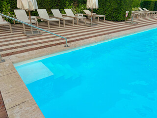 Outdoor swimming pool in luxury hotel on sunny summer day. Time for relax