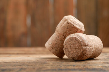 Corks of wine bottles on wooden table, closeup. Space for text