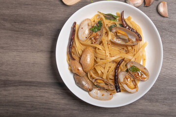 Pasta stir-fried with clams with basil and chili