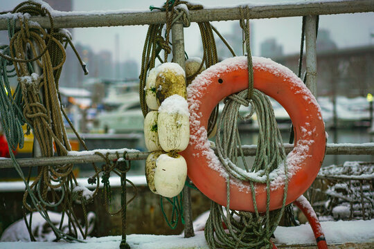 A life preserver and buoys on a snowy fishing boat