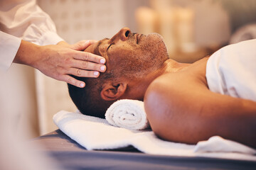 Hands, head and massage with a man in a spa on a bed or table for wellness, luxury or stress relief...