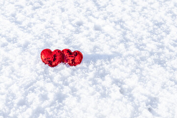 Two red hearts on a background of white snow. Place for an inscription. Copyspace. Valentine's Day.