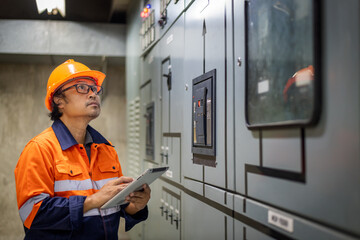 The engineer checking and inspecting at MDB panel .he working with electric switchboard to check...