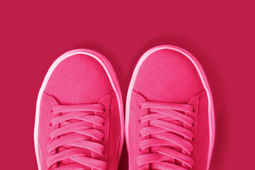 Female sneakers fashion trend color 2023 Viva Magenta close-up, top view.