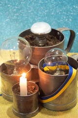 Lights off or power outage in Ukraine - burning candle and dead dark electricity lamps off 
