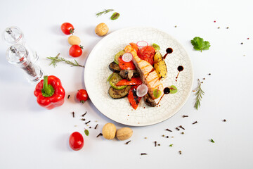 Dish red fish with vegetables on a white background.