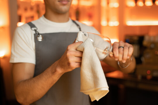 barman polishing the wine glass working in cafe bar.