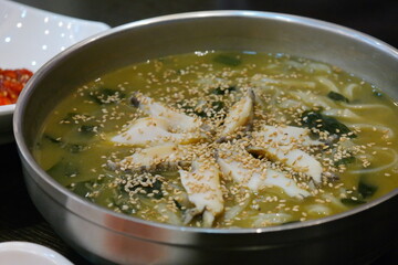 A bowl of abalone noodles topped with sesame seeds